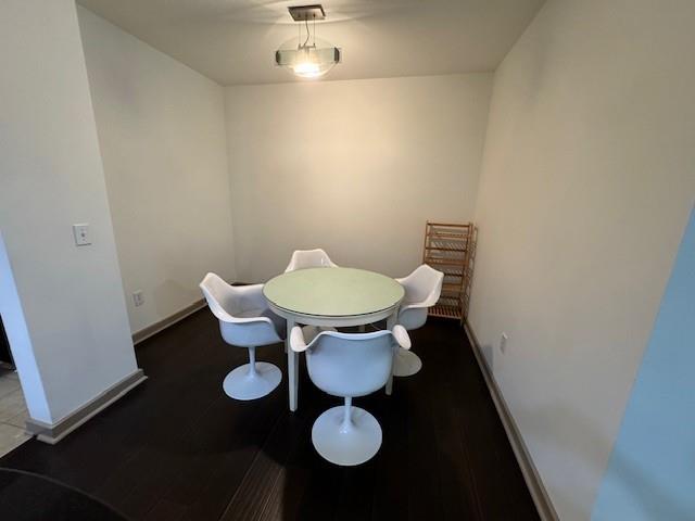 dining space featuring baseboards and wood finished floors