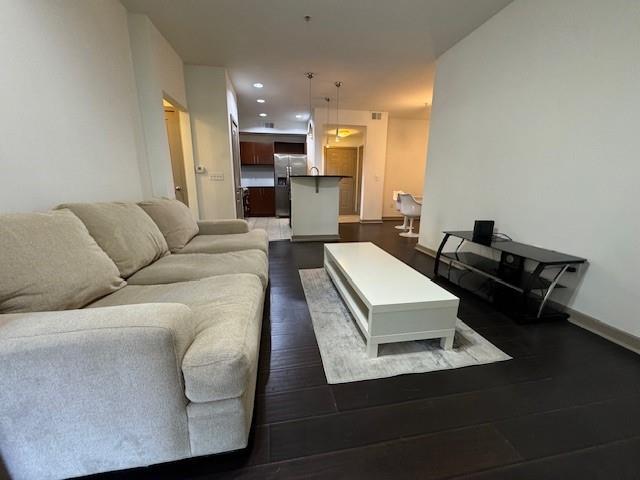living room with baseboards, recessed lighting, and dark wood-style floors