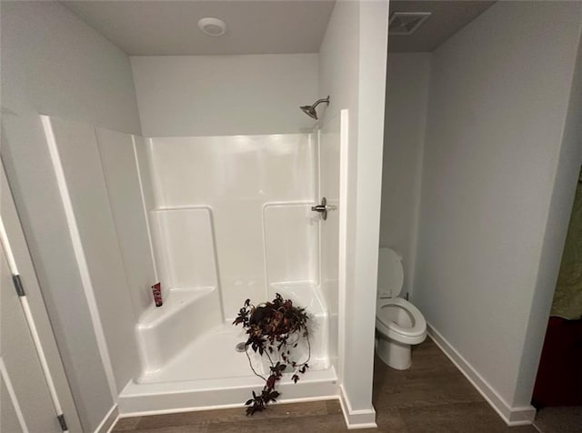 bathroom with walk in shower and toilet