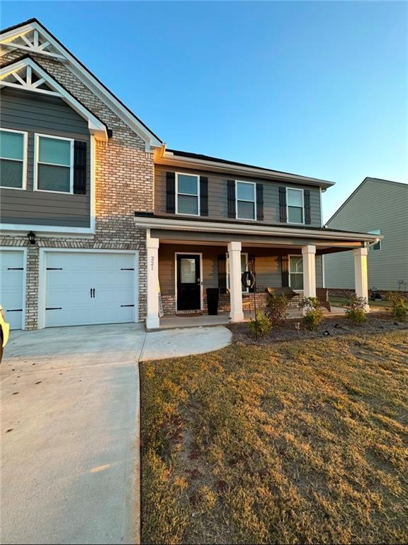 view of front of home with a porch, a garage, and a front lawn