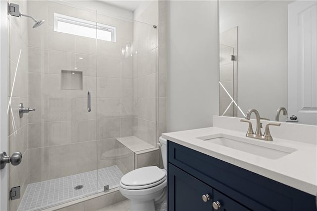 bathroom with vanity, toilet, and a shower with door