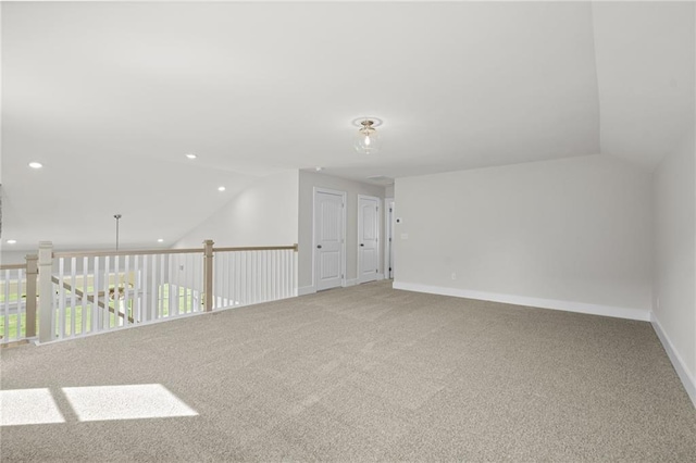 spare room with carpet floors and vaulted ceiling