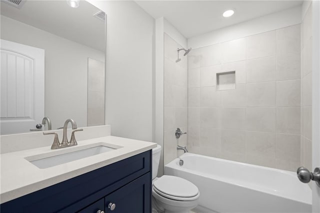 full bathroom with tiled shower / bath combo, toilet, and vanity