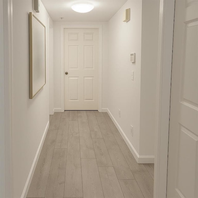 hallway featuring light wood-style floors and baseboards