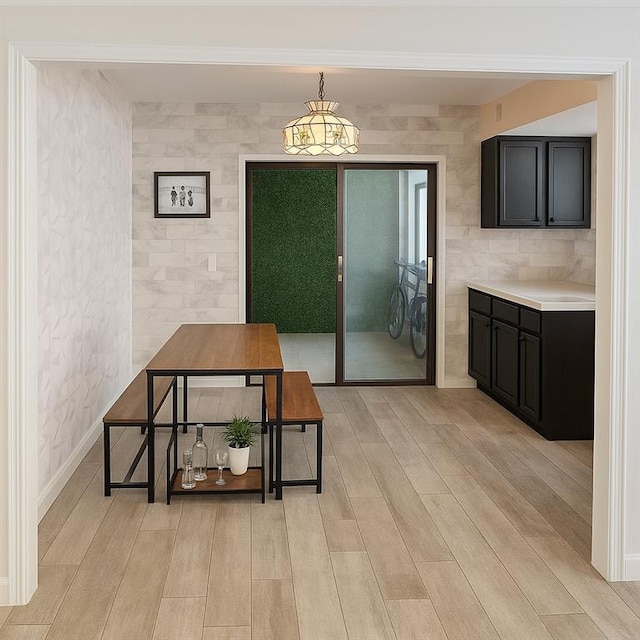dining space with light wood-style flooring and tile walls