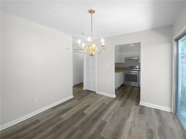 unfurnished dining area featuring an inviting chandelier and dark hardwood / wood-style flooring