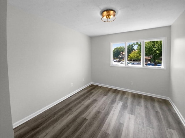 spare room featuring dark wood-type flooring