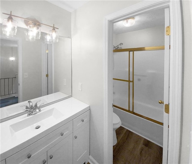 full bathroom featuring wood-type flooring, toilet, enclosed tub / shower combo, and vanity