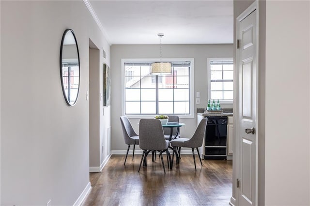 dining room with ornamental molding, dark hardwood / wood-style floors, and a healthy amount of sunlight