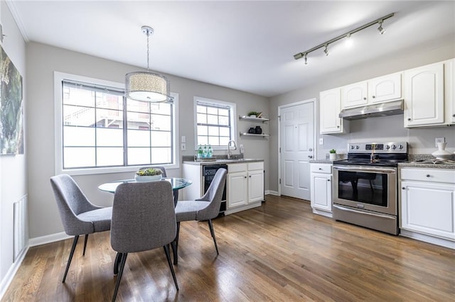 kitchen with pendant lighting, sink, white cabinets, stainless steel range with electric stovetop, and dark wood-type flooring