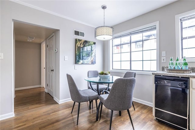 dining room with ornamental molding and dark hardwood / wood-style floors