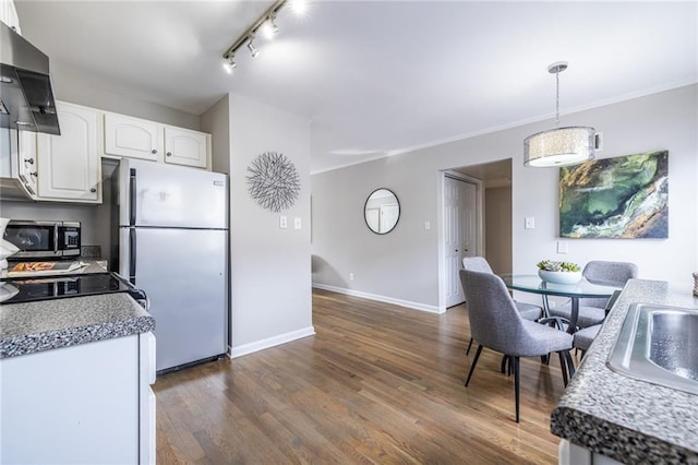 kitchen with white cabinetry, extractor fan, pendant lighting, and appliances with stainless steel finishes