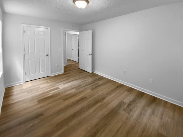 355 Marietta Hwy, Roswell, GA 30075 - unfurnished bedroom featuring a textured ceiling, baseboards, and wood finished floors