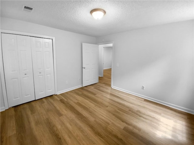 355 Marietta Hwy, Roswell, GA 30075 - unfurnished bedroom with wood finished floors, a textured ceiling, baseboards, and a closet
