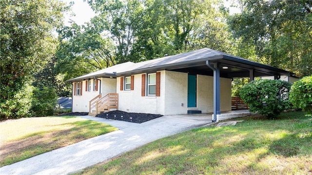 ranch-style home with driveway, an attached carport, a front lawn, and brick siding