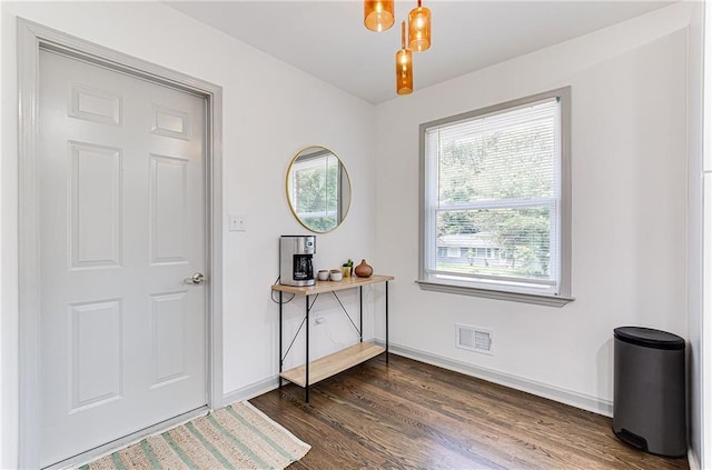 entryway with dark wood-style flooring, visible vents, and baseboards