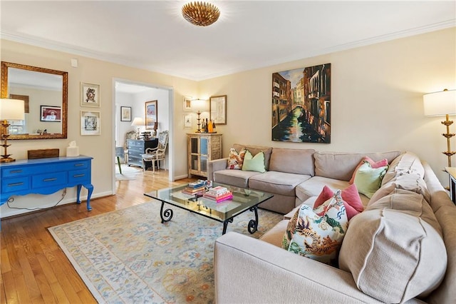 living area featuring ornamental molding, hardwood / wood-style flooring, and baseboards