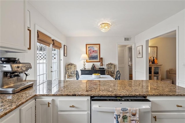 kitchen featuring wine cooler, stone countertops, a peninsula, visible vents, and white cabinetry