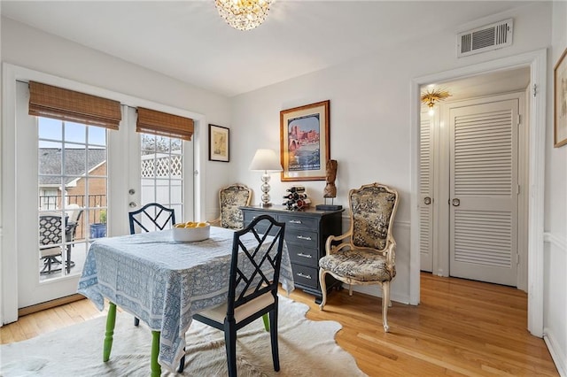 dining area featuring light wood-style flooring, visible vents, and baseboards