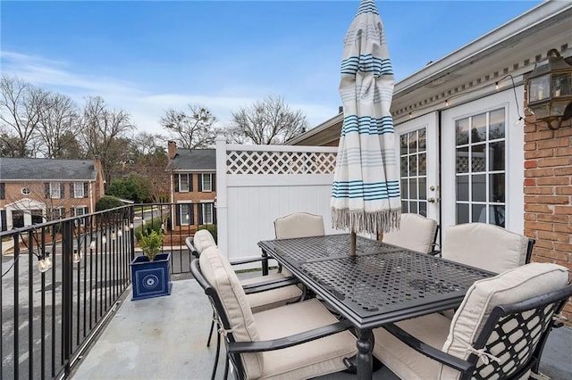 view of patio with french doors, outdoor dining area, and a balcony