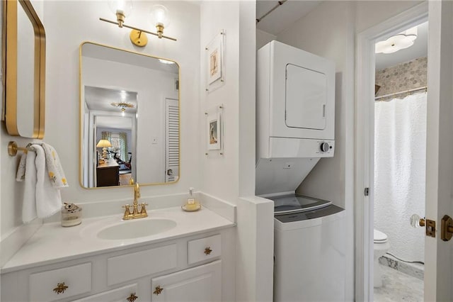 full bathroom featuring stacked washer / dryer, a shower with curtain, vanity, and toilet