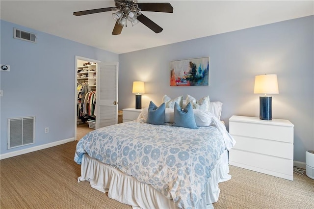 bedroom with a spacious closet, carpet, and visible vents