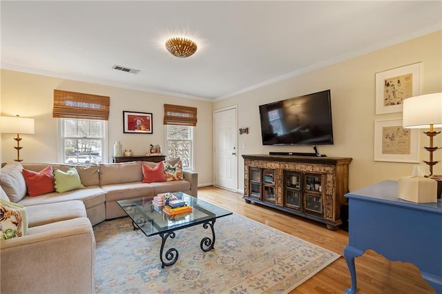 living room featuring ornamental molding, visible vents, and wood finished floors