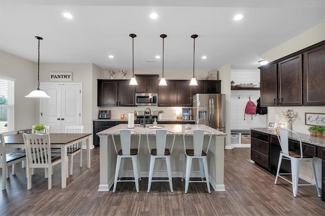 7 Wilmer Way, Cartersville, GA 30120 - kitchen featuring stainless steel appliances, dark brown cabinetry, dark wood-style floors, hanging light fixtures, and light stone counters