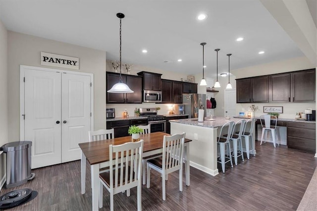 7 Wilmer Way, Cartersville, GA 30120 - kitchen featuring appliances with stainless steel finishes, dark wood-style flooring, dark brown cabinets, a center island, and pendant lighting