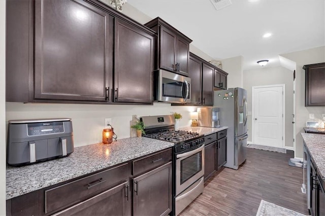 7 Wilmer Way, Cartersville, GA 30120 - kitchen with stainless steel appliances, dark brown cabinetry, wood finished floors, light stone countertops, and recessed lighting