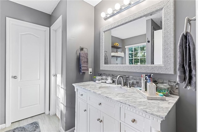 bathroom featuring vanity, baseboards, and wood finished floors