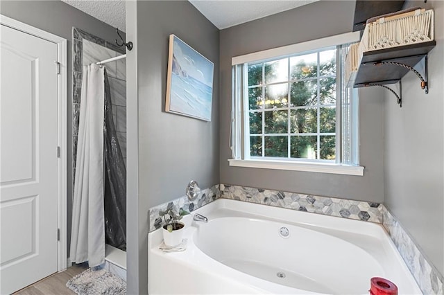 bathroom featuring a textured ceiling, a bath, and a shower with curtain