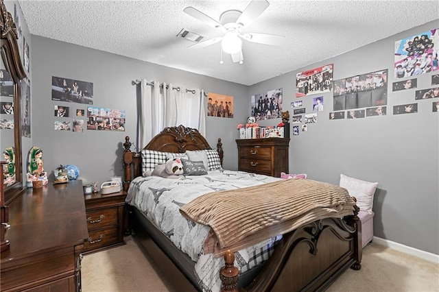 bedroom featuring baseboards, visible vents, a ceiling fan, light colored carpet, and a textured ceiling