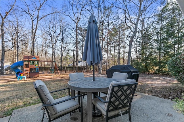 view of patio featuring area for grilling, outdoor dining space, and a playground