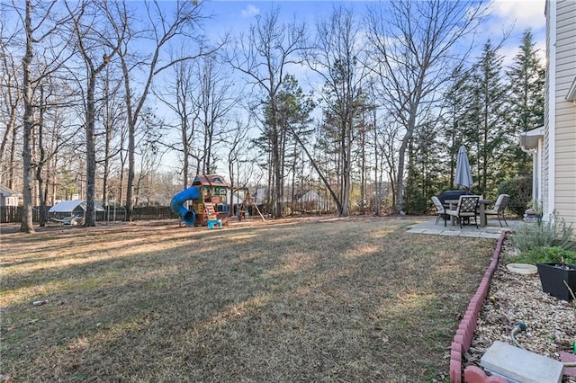 view of yard with a patio area, fence, and a playground