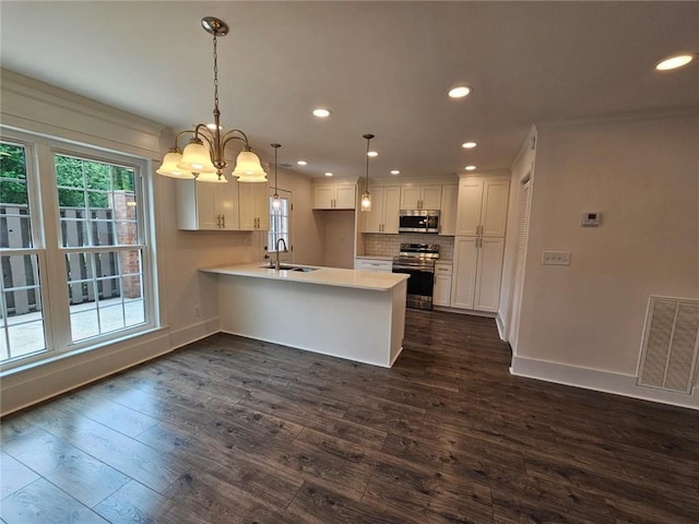 kitchen featuring stainless steel appliances, dark hardwood / wood-style flooring, white cabinets, pendant lighting, and sink