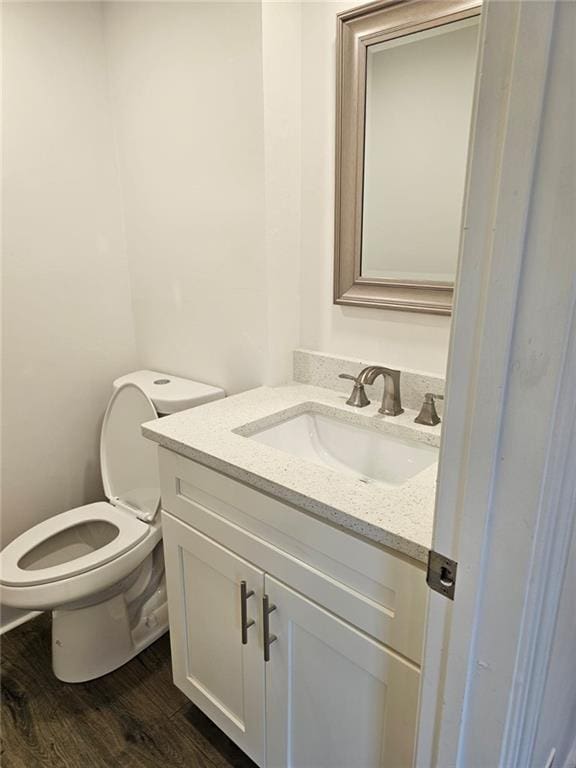 bathroom with vanity, toilet, and wood-type flooring