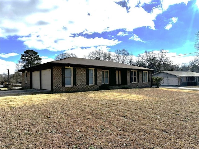 ranch-style home featuring a garage and a front lawn