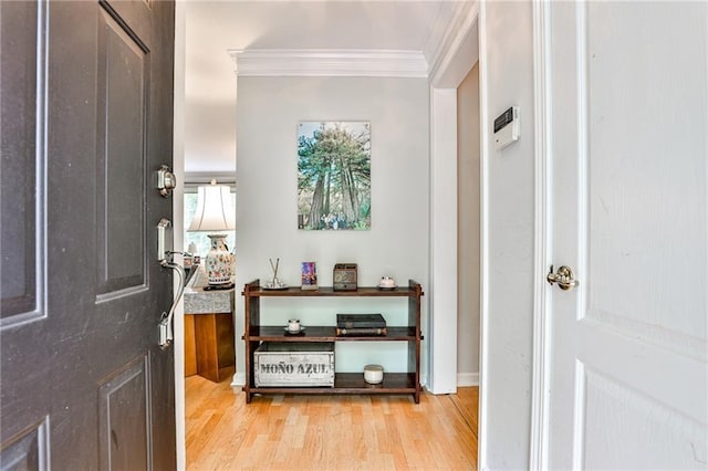 foyer with light wood-style flooring and ornamental molding