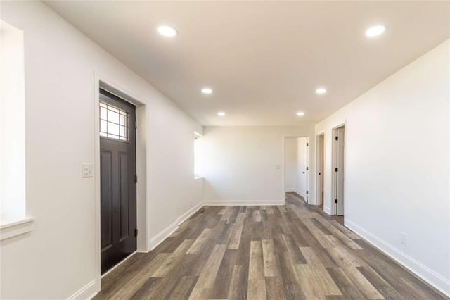 spare room with baseboards, dark wood-style flooring, and recessed lighting