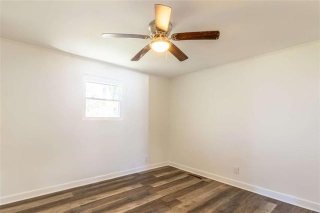 spare room with ceiling fan, baseboards, and dark wood-type flooring