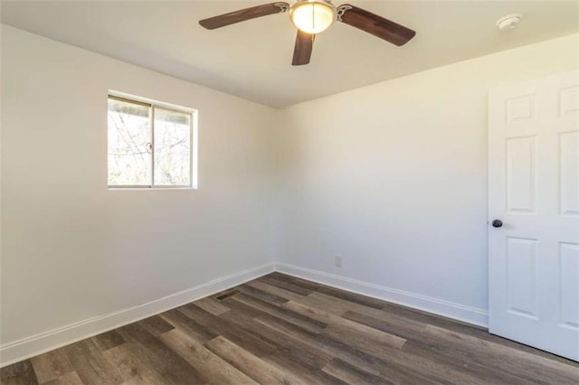 spare room with ceiling fan, baseboards, and dark wood finished floors