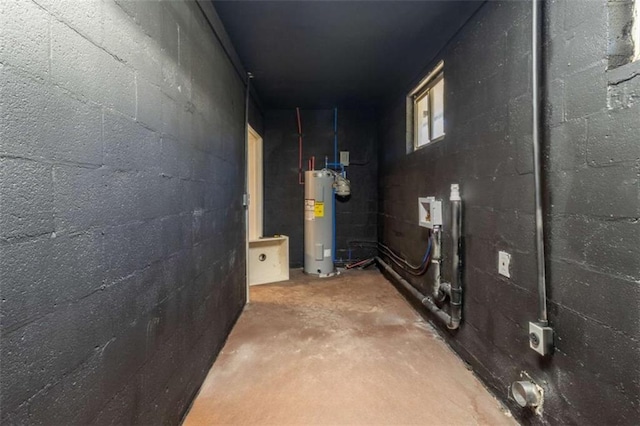 unfinished below grade area featuring electric water heater and concrete block wall