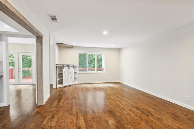 unfurnished living room with dark hardwood / wood-style floors, a healthy amount of sunlight, and french doors