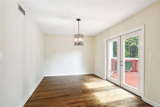 interior space with french doors, dark wood-type flooring, and a notable chandelier