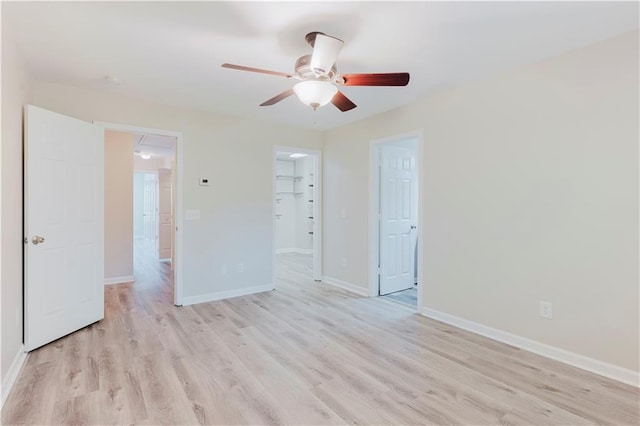 unfurnished room with a ceiling fan, light wood-style floors, and baseboards