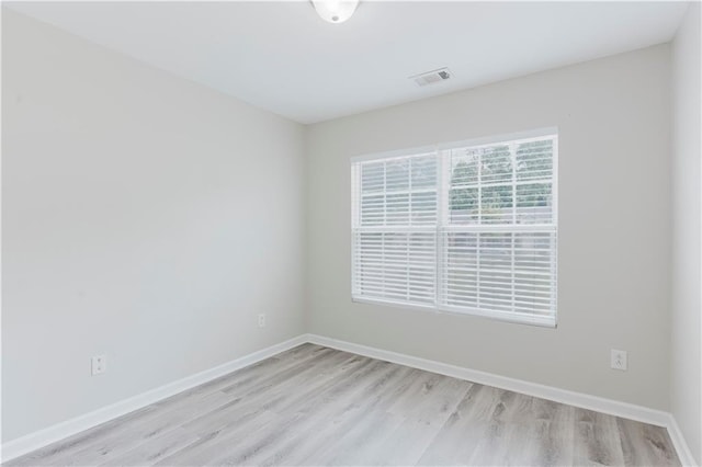 spare room with light wood-style flooring and baseboards