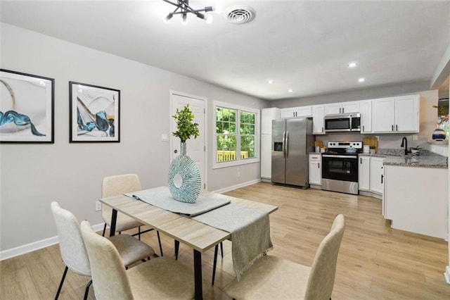 dining room featuring recessed lighting, baseboards, visible vents, and light wood finished floors