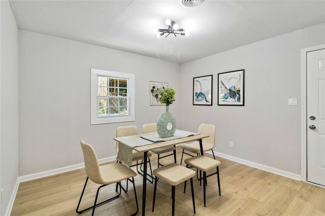 dining space featuring baseboards, visible vents, and light wood-style floors