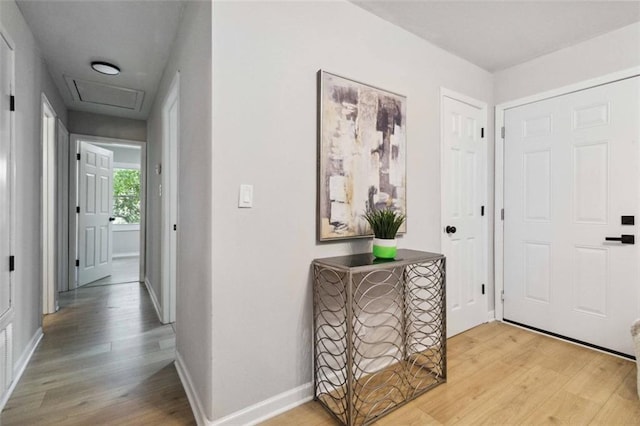 foyer with light wood-style flooring and baseboards